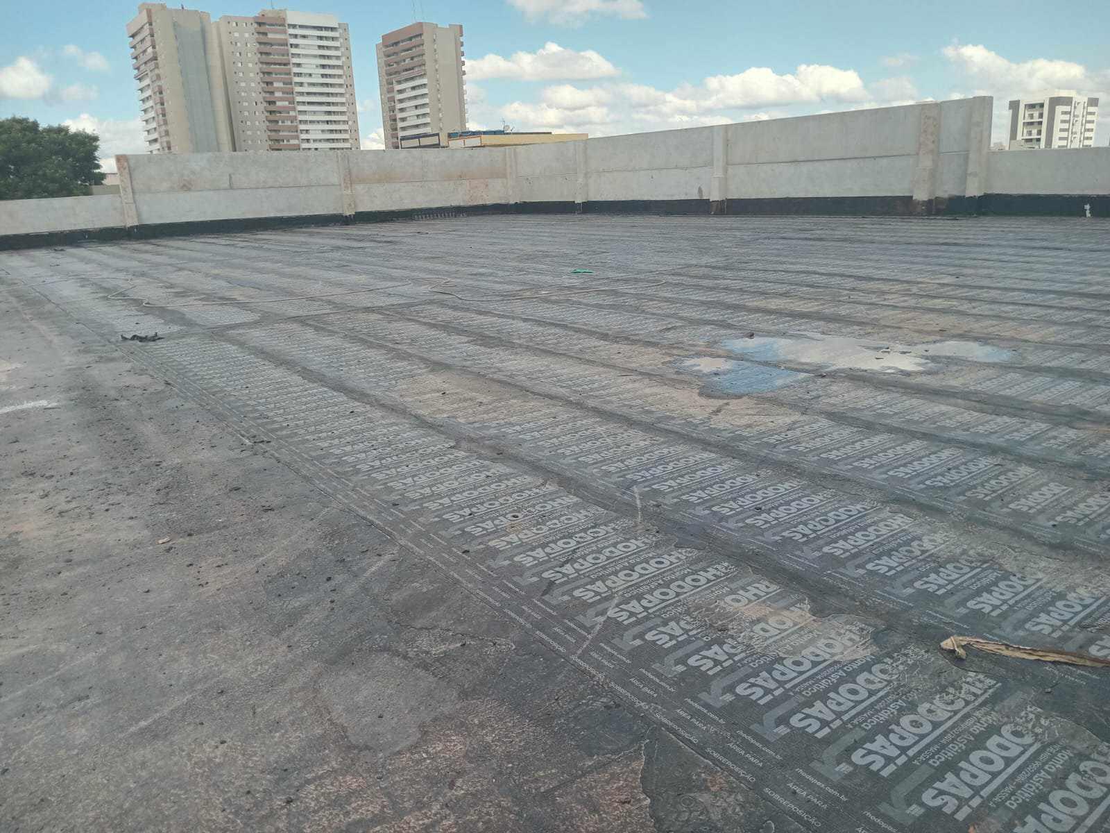 Impermeabilização de laje com manta asfáltica, colada com asfalto quente.