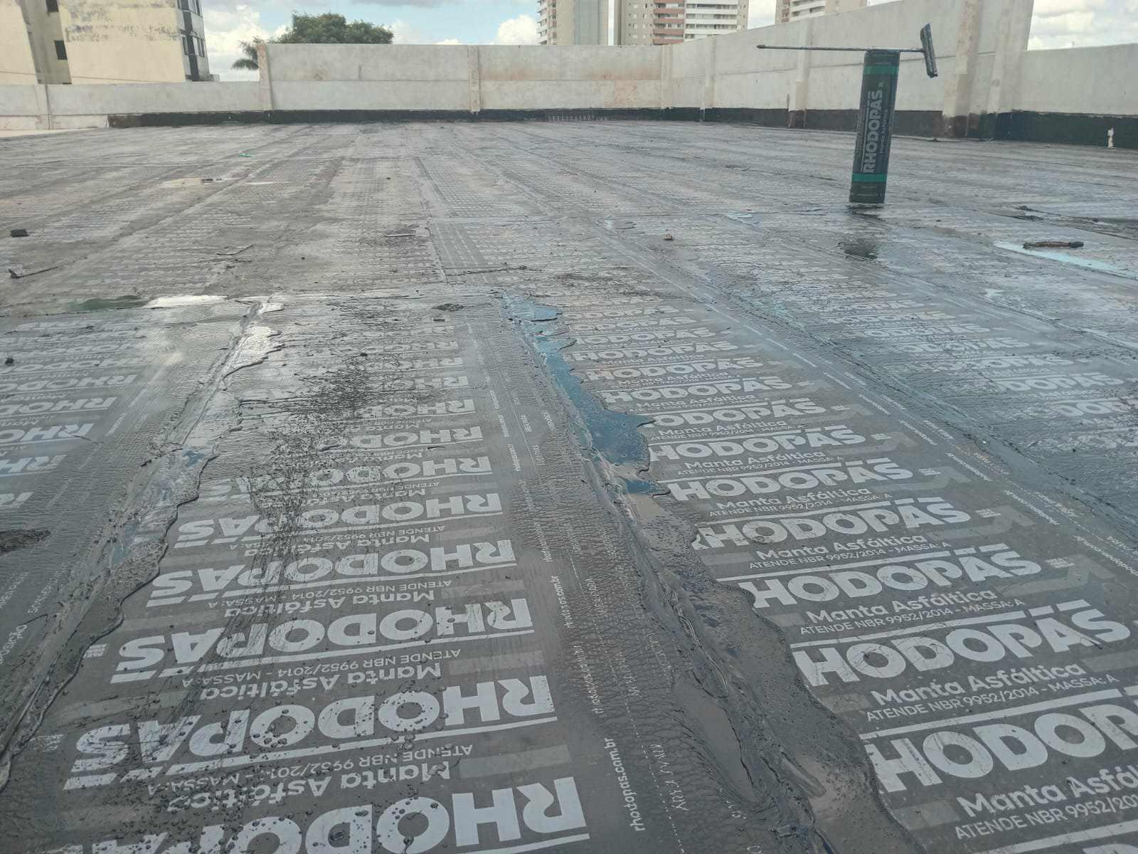 Impermeabilização de laje com manta asfáltica, colada com asfalto quente.