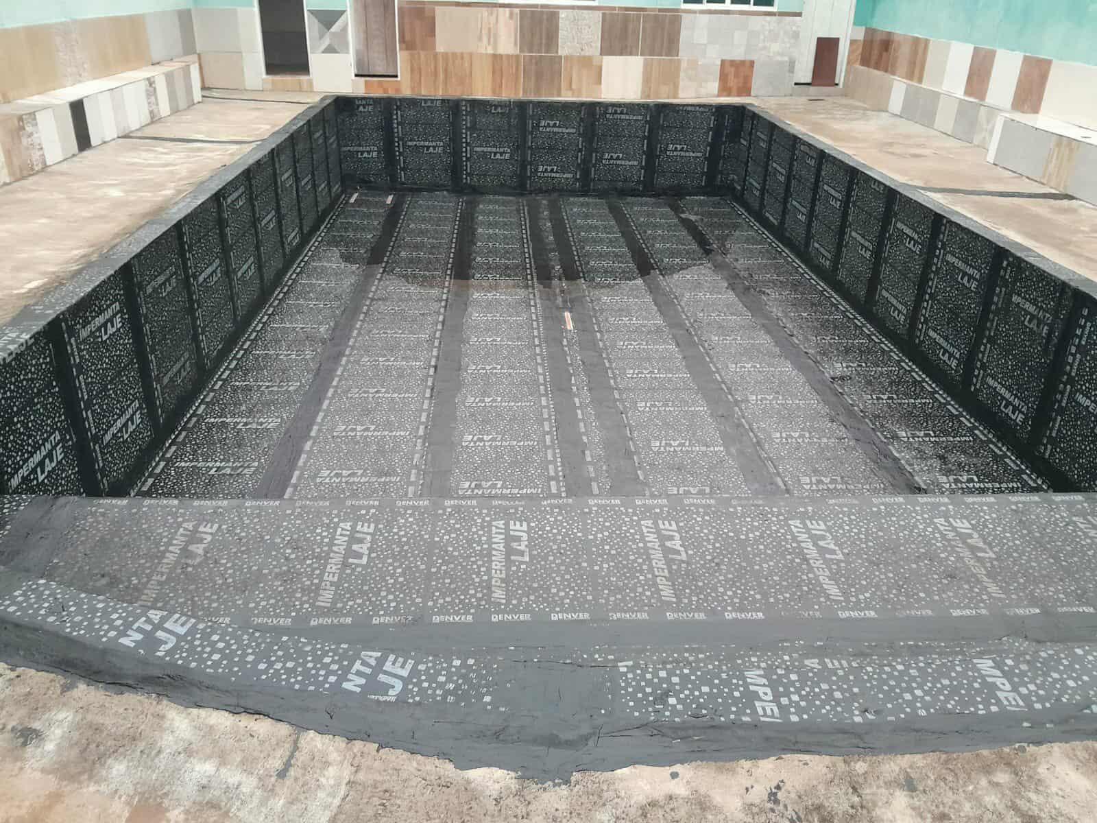 Impermeabilização de piscina com manta asfáltica, aderida com asfalto quente.