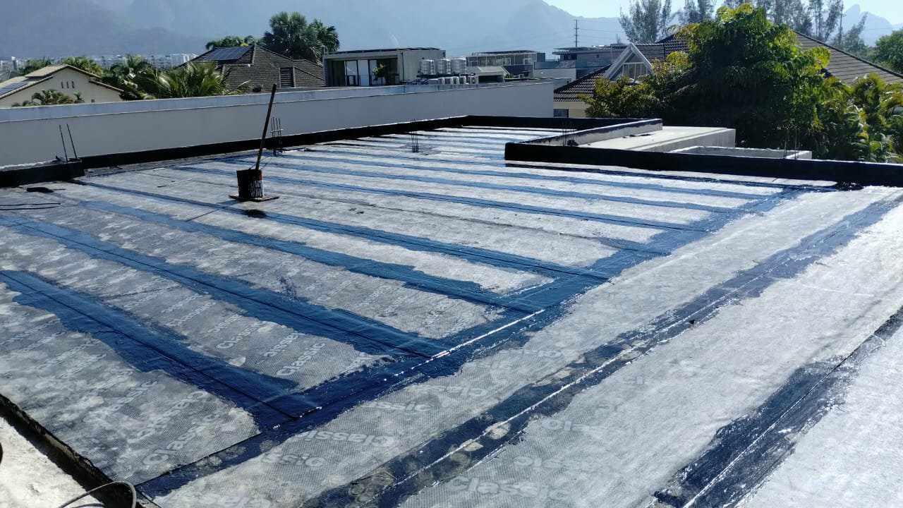 Impermeabilização de laje com manta asfáltica e colada com asfalto quente.