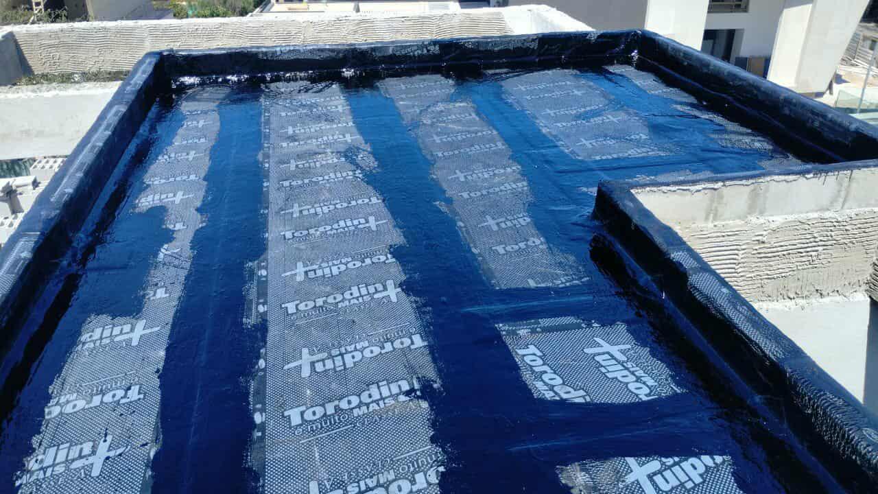 Impermeabilização de laje, com manta asfáltica colada com asfalto quente.